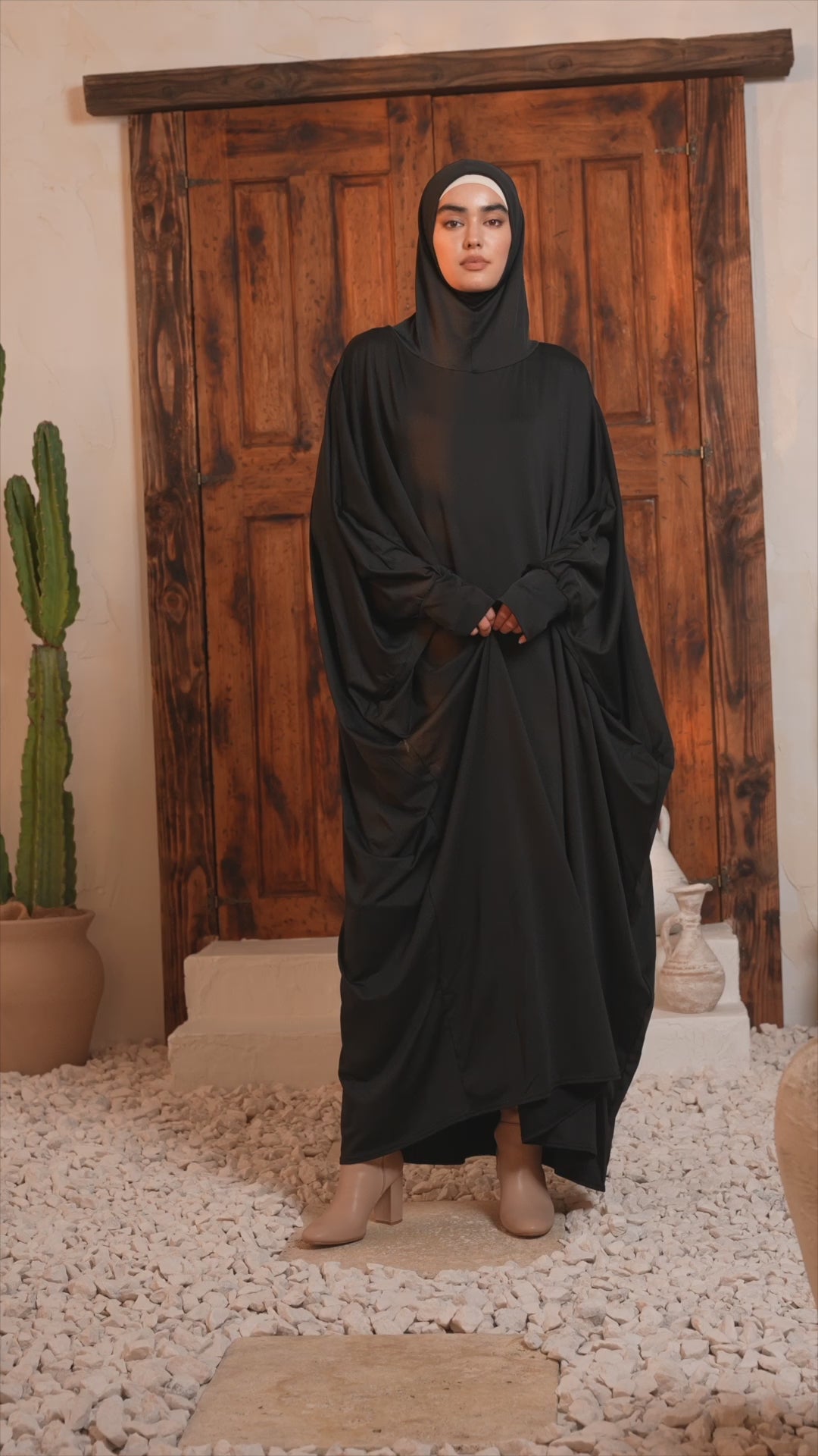 Black one-piece Salah prayer outfit with hood, displayed indoors, featuring breathable and comfortable fabric.
