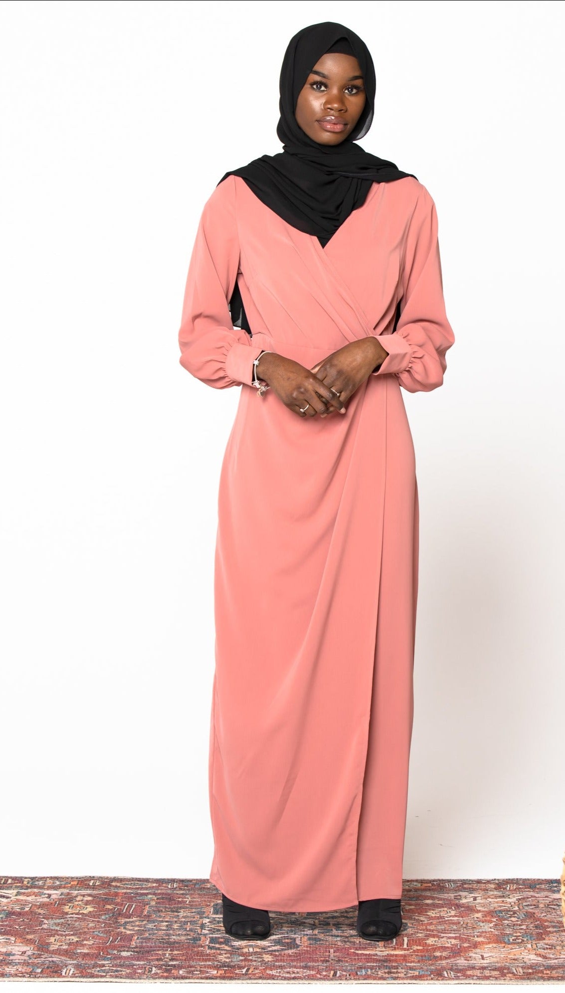 Woman in coral wrap maxi dress and black hijab on clearance