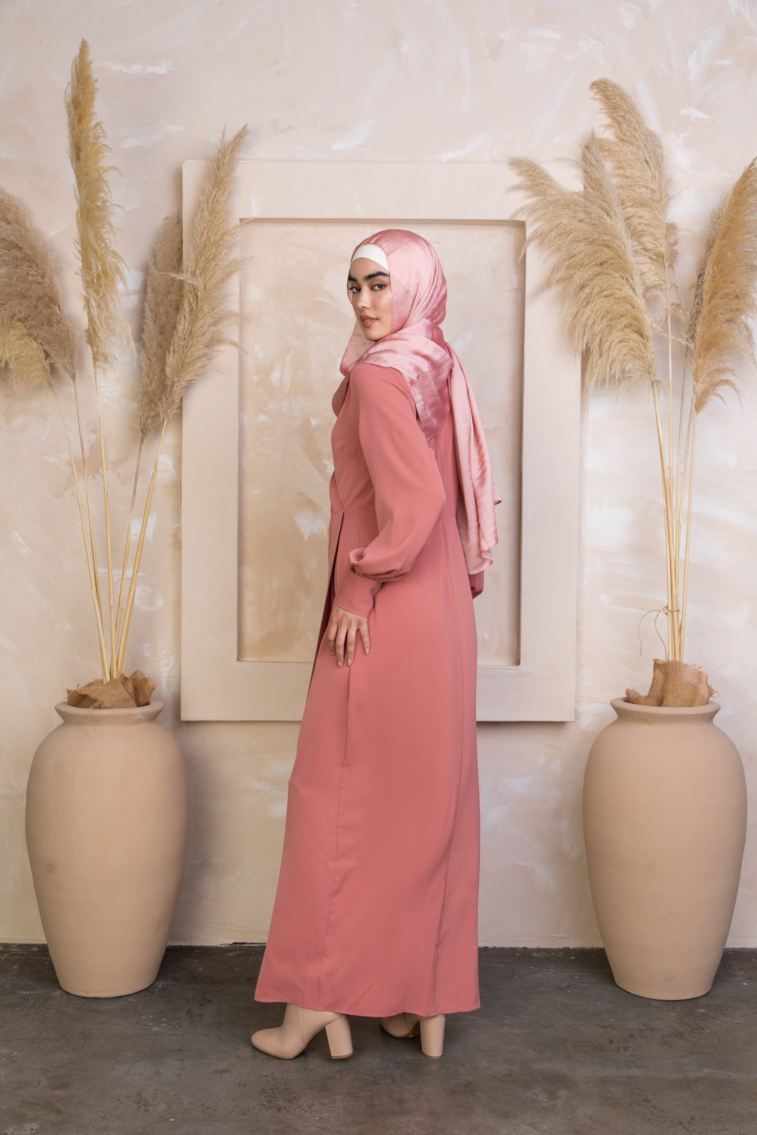Woman in long pink coral wrap maxi dress and hijab on clearance