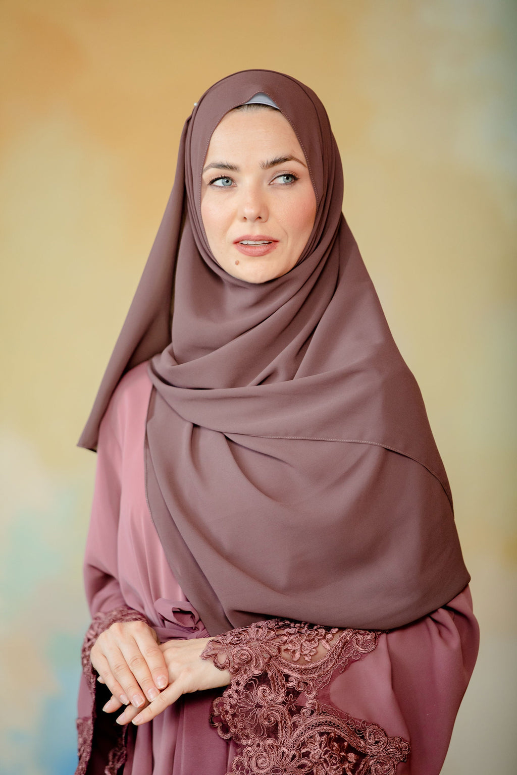 Woman in hijab and embroidered dress in dark brown chiffon