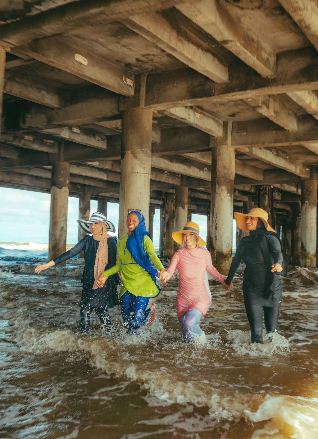 Four women modeling ruched 3-piece modest burkini swimsuit